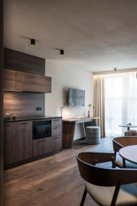 een woonkamer met een keuken met houten kasten en een tafel bij Bella Posta Hotel in Soprabolzano