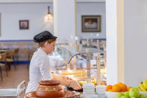 a woman is preparing food in a bakery at Moon Dreams El Cortijo in Matalascañas