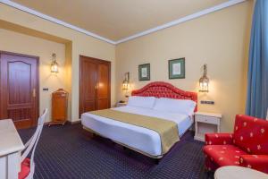 a hotel room with a bed and a red chair at Moon Dreams El Cortijo in Matalascañas