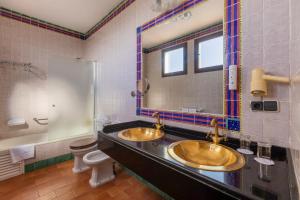 a bathroom with two sinks and a toilet and a mirror at Moon Dreams El Cortijo in Matalascañas