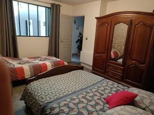 1 dormitorio con 2 camas y vestidor con espejo en L'Écurie de Lili entre Bourges et Sancerre, en Azy