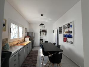 a kitchen with a table and chairs and a counter at The White House - Aianteio in Aiándion