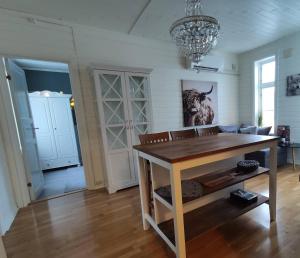 a living room with a table and a chandelier at Charming central apartment in Narvik