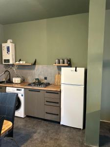 a kitchen with a white refrigerator and a stove at Guest Hous in Urekis Sadguri +6 photos