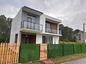 a white house with a fence in front of it at Guest Hous in Urekis Sadguri
