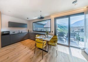 Una cocina y un comedor con una mesa y sillas amarillas. en Kandlerhof, en Bolzano