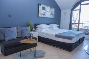 a blue bedroom with a bed and a couch at Black sea Narcissus - quiet studio with amazing sea view in Varna City