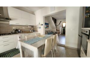 a kitchen and dining room with a table and chairs at Casetta Milù in Lu Lioni