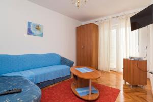 sala de estar con sofá azul y mesa en Villa Victory, en Umag