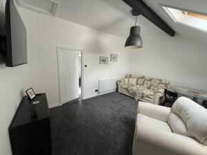 a white living room with a couch and a table at Room above the Inn in Bristol