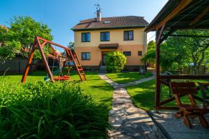 a yard with a playground in front of a house at Penzion Na Vyhlídce in Lukov