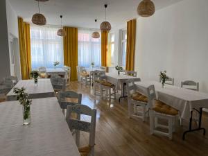 a room with white tables and chairs and windows at Jaśmin -pokoje gościnne in Ustka