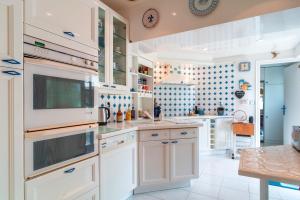 a kitchen with white cabinets and a counter top at Gwell Ar Ster - Maison à 400 m de la plage in Bénodet