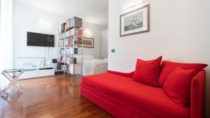 a living room with a red couch and a table at Italianway - Tadino 1 A in Milan +24 photos