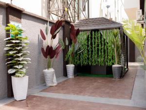 a gazebo with potted plants on a building at Edgewoodapartment in Jiru
