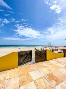a view of the beach from a resort with a yellow wall at Pousada o Èdio in Beberibe
