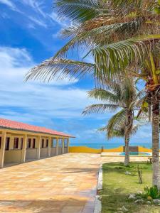 a palm tree in front of a building at Pousada o Èdio in Beberibe
