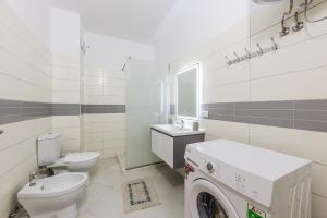 a bathroom with a toilet sink and a washing machine at Ivory Rose Apartment in Vlorë +22 photos