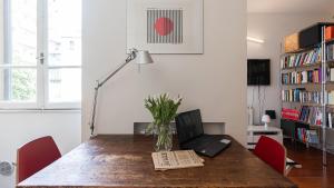 a dining room table with a laptop and a book at Italianway - Tadino 1 A in Milan