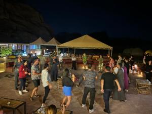 een groep mensen die 's avonds dansen op een feestje bij Wadi Rum Legend Luxury Camp in Wadi Rum