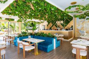 a restaurant with tables and chairs and plants at Harmony Suites Grand Resort 16 in Sunny Beach