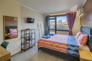 a small bedroom with a bed and a window at Globus Kiten in Kiten