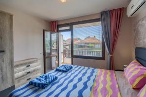 a bedroom with a bed and a large window at Globus Kiten in Kiten