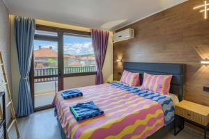 a bedroom with a bed and a balcony at Globus Kiten in Kiten +158 photos