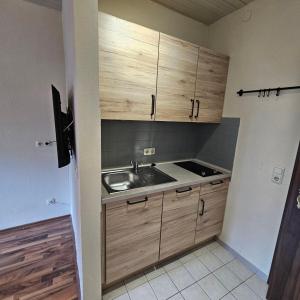 a kitchen with wooden cabinets and a sink at Malerhaus Ferienwohnungen in Bad Reichenhall +29 photos