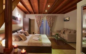 Caretta Village في توروني: غرفة نوم بسرير كبير وأريكة