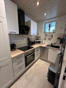 a kitchen with white cabinets and a sink at Appartement Schönblick mit Indoorpool in Oberteuringen