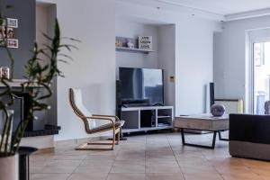 a living room with a tv and a chair at Seaside Grey Pearl Villa Panoramic Marina View Piraeus Athens Riviera in Piraeus