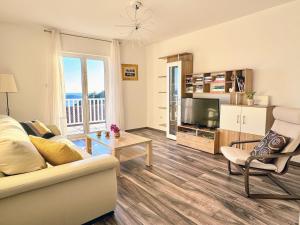 a living room with a couch and a television at Indigo Cavtat Apartments in Cavtat