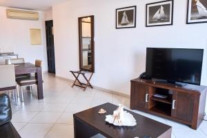 Elegant 1-Bedroom Duplex Apartment في سانتا ماريا: غرفة معيشة مع تلفزيون بشاشة مسطحة وطاولة