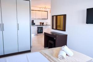 Elegant 1-Bedroom Duplex Apartment في سانتا ماريا: مطبخ مع سرير ومكتب في الغرفة