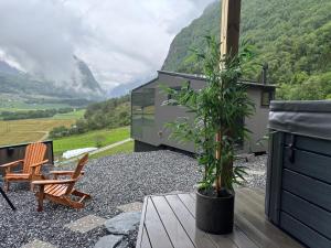 a patio with a chair and a potted plant at Panoramahytte med utsikt mot Eggenipa in Egge