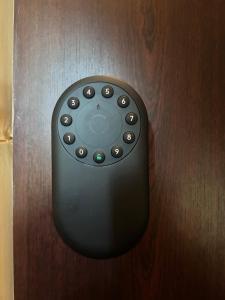 a black remote control hanging on a wooden wall at Elegant seaside stay - Vitolu street apartment in Liepāja