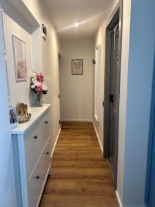 a hallway with white cabinets and wood floors at Elegant seaside stay - Vitolu street apartment in Liepāja