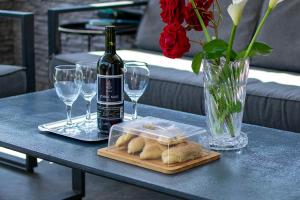 a table with a bottle of wine and a tray of bread at Apartman Lara in Krapina