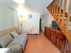 un salon avec un canapé et un escalier dans l'établissement Duplex T3 6 pers - Saint-Lary-Soulan avec TV, parking, casier à skis - FR-1-457-352, à Saint-Lary-Soulan