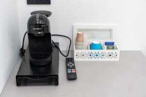 Eine Kaffeemaschine und eine Fernbedienung auf einer Theke in der Unterkunft CrystalRooms in Leverano