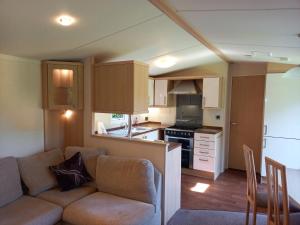 a living room with a couch and a kitchen at Emma 6 in Menai Bridge