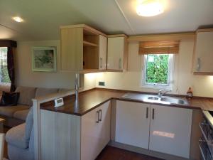 a kitchen with a sink and a couch in a room at Emma 6 in Menai Bridge +16 photos