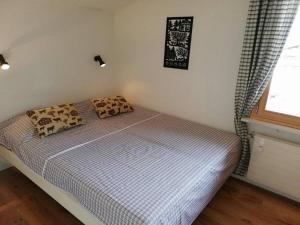 a bed in a bedroom with two pillows on it at Central Location Cozy 3 BR Flat in Gstaad in Gstaad