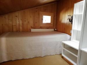 a bedroom with a bed in a wooden wall at Central Location Cozy 3 BR Flat in Gstaad in Gstaad +6 photos