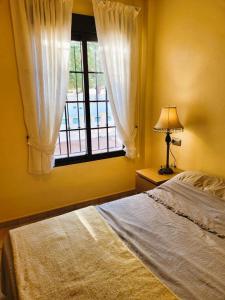 a bedroom with a bed and a window at Juweeltje van Hondon, met groot zwembad en rust in Hondón de las Nieves