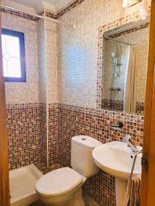 a bathroom with a toilet and a sink and a mirror at Juweeltje van Hondon, met groot zwembad en rust in Hondón de las Nieves