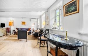 a living room with a table and chairs at Cozy Home In Allinge With Kitchen in Allinge