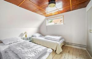 two beds in a room with a ceiling at Cozy Home In Allinge With Kitchen in Allinge +23 photos