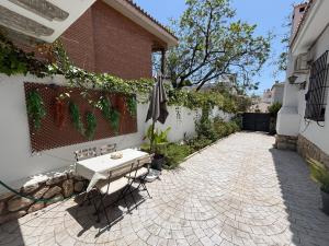 un patio con una mesa y una sombrilla junto a un edificio en Apartamento a 2 minutos de la playa, en Málaga